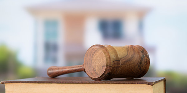 gavel on a book with a blurred house in the background