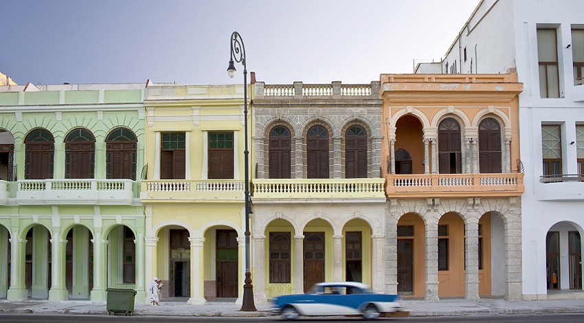 Colorful buildings and an antique car on the street in Cuba