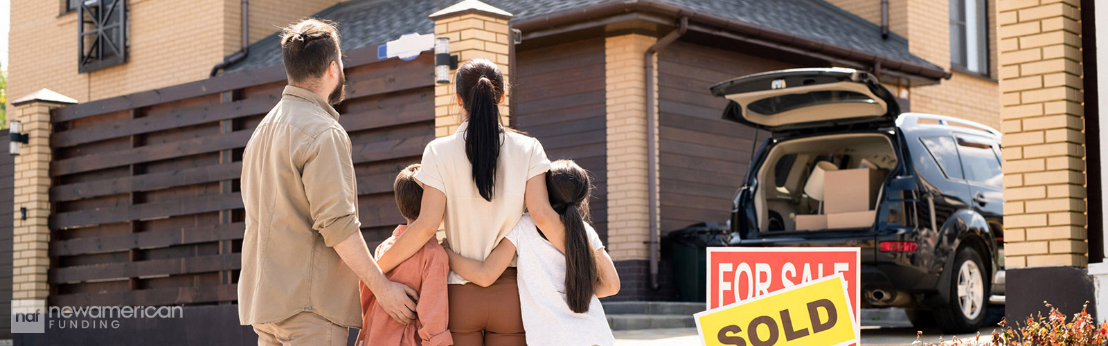 family standing outside looking at a home with a 