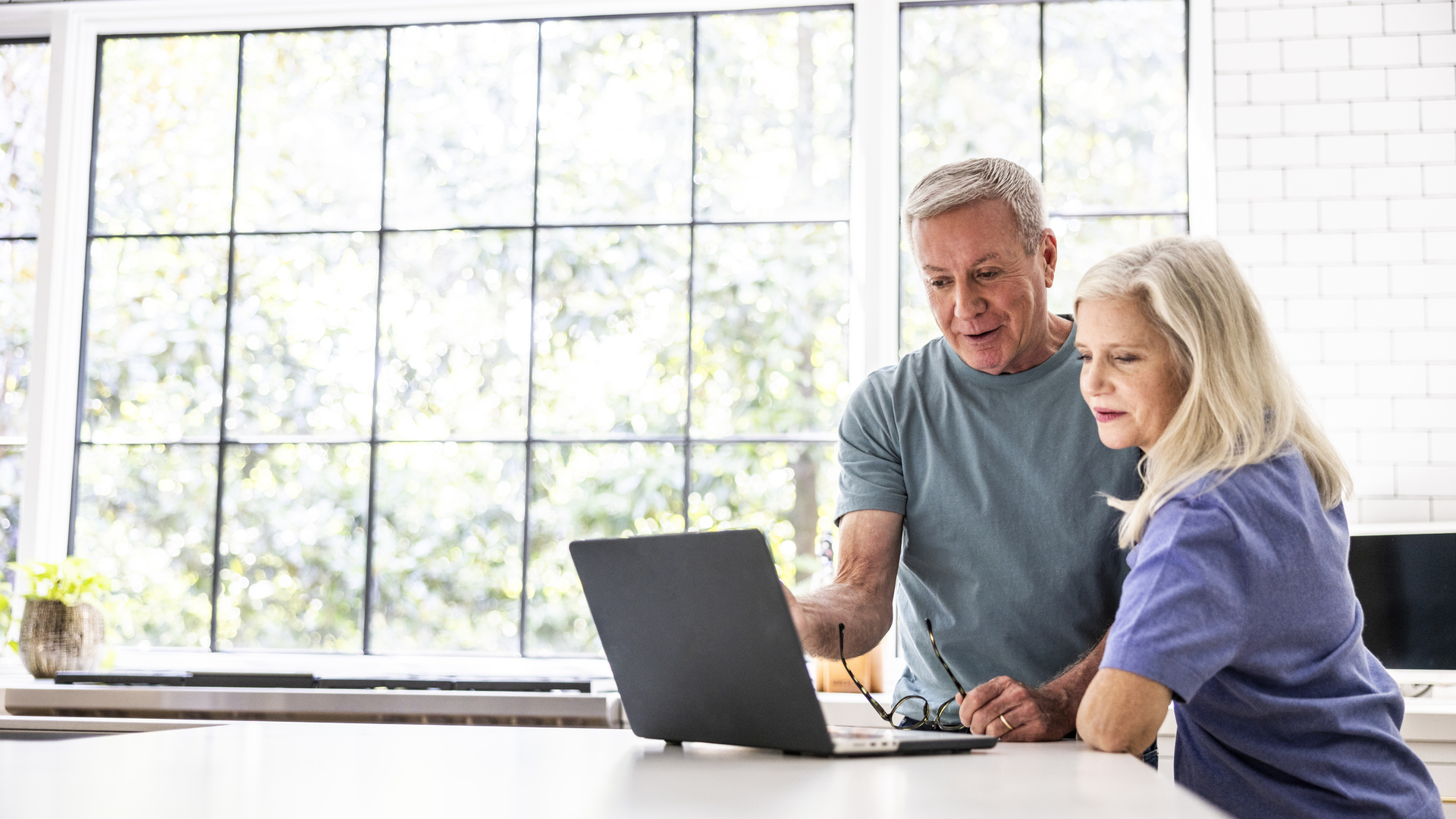 Senior couple using laptop in kitchen