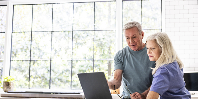 Senior couple using laptop in kitchen