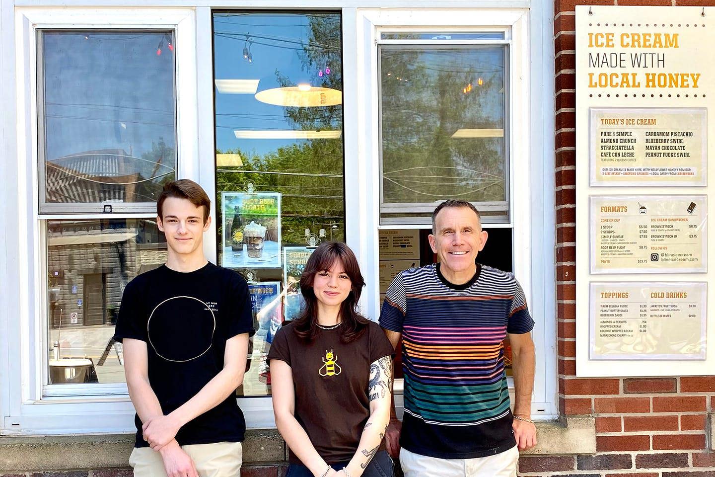 Randall and two associates stand smiling outside the B-Line ice cream shop in Narrowsburg, New York.