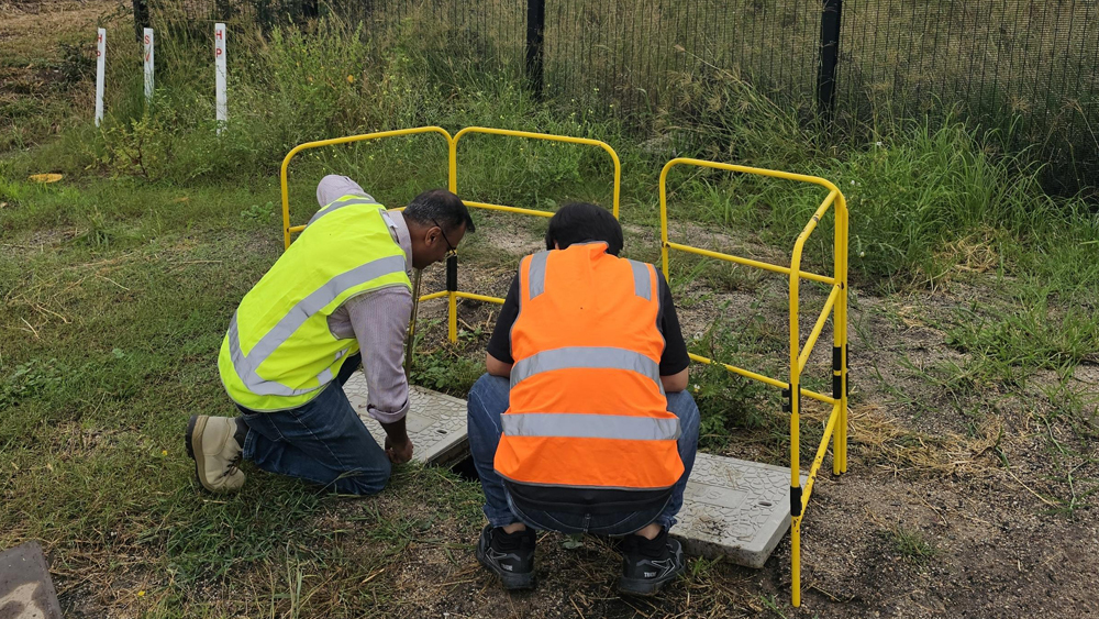 Picture of two Vocus workers in high vis working on a pit at Western Sydney Airport