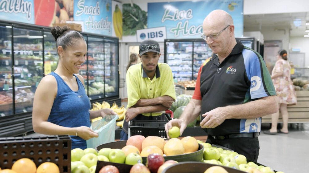 Photo of CEQ employee talking to community members at a supermarket