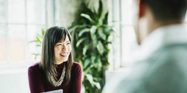 Smiling businesswoman leading project meeting in office conference room