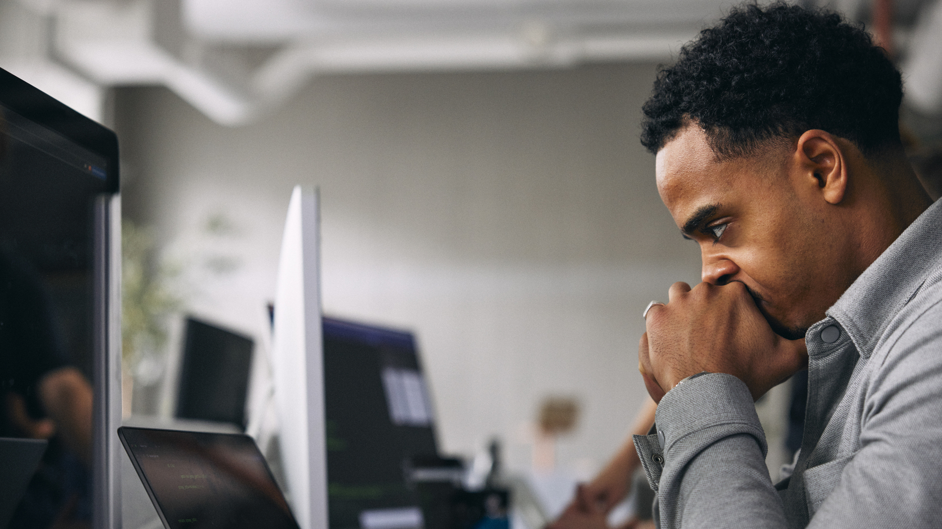 Exhausted male computer programmer at tech startup office
