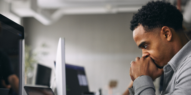 Exhausted male computer programmer at tech startup office