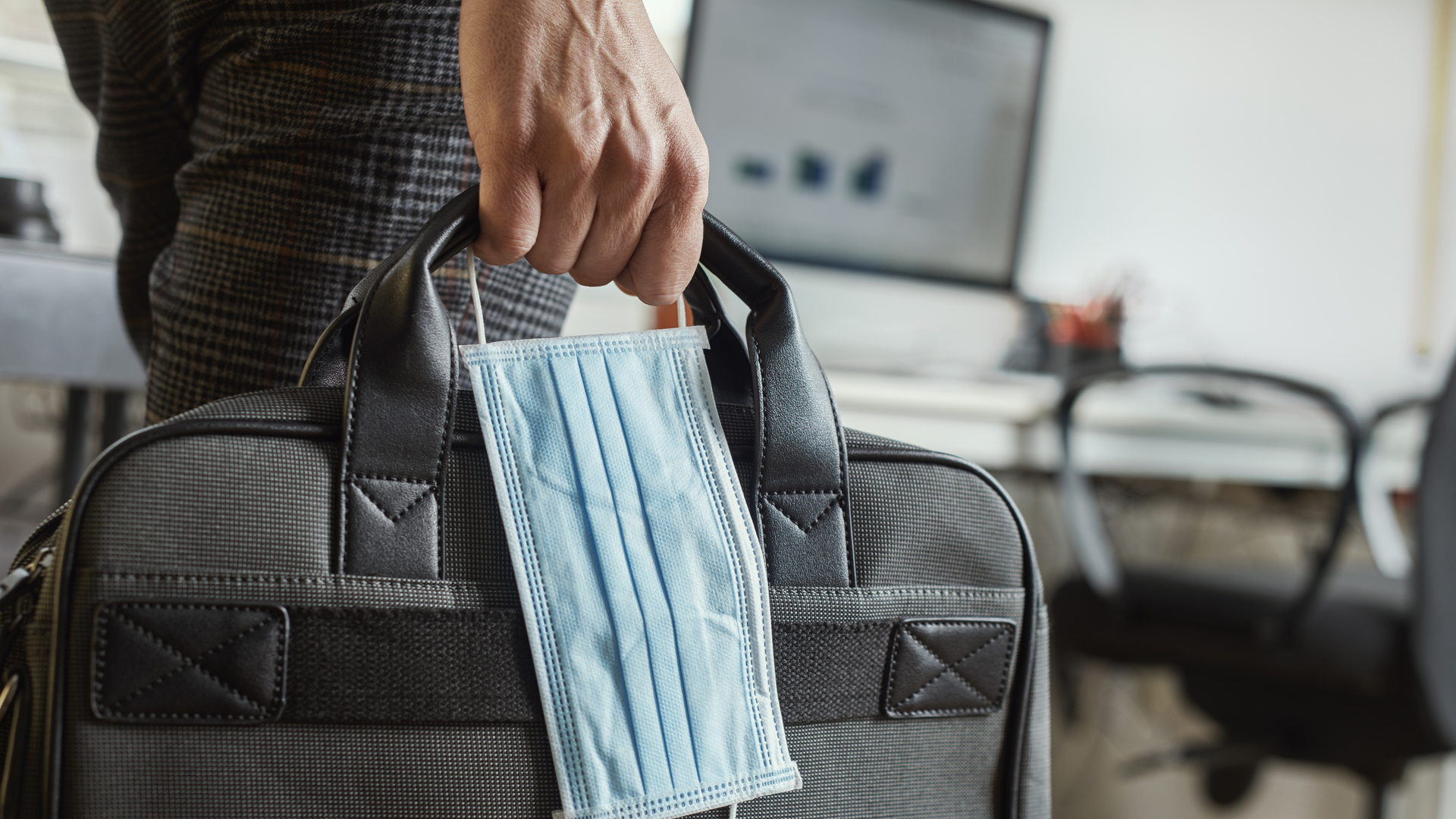 man with a briefcase and a surgical mask