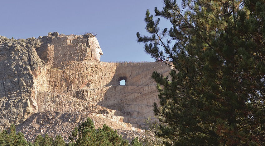 The Crazy Horse Monument carved from the rock, with its face and the top of its arm complete
