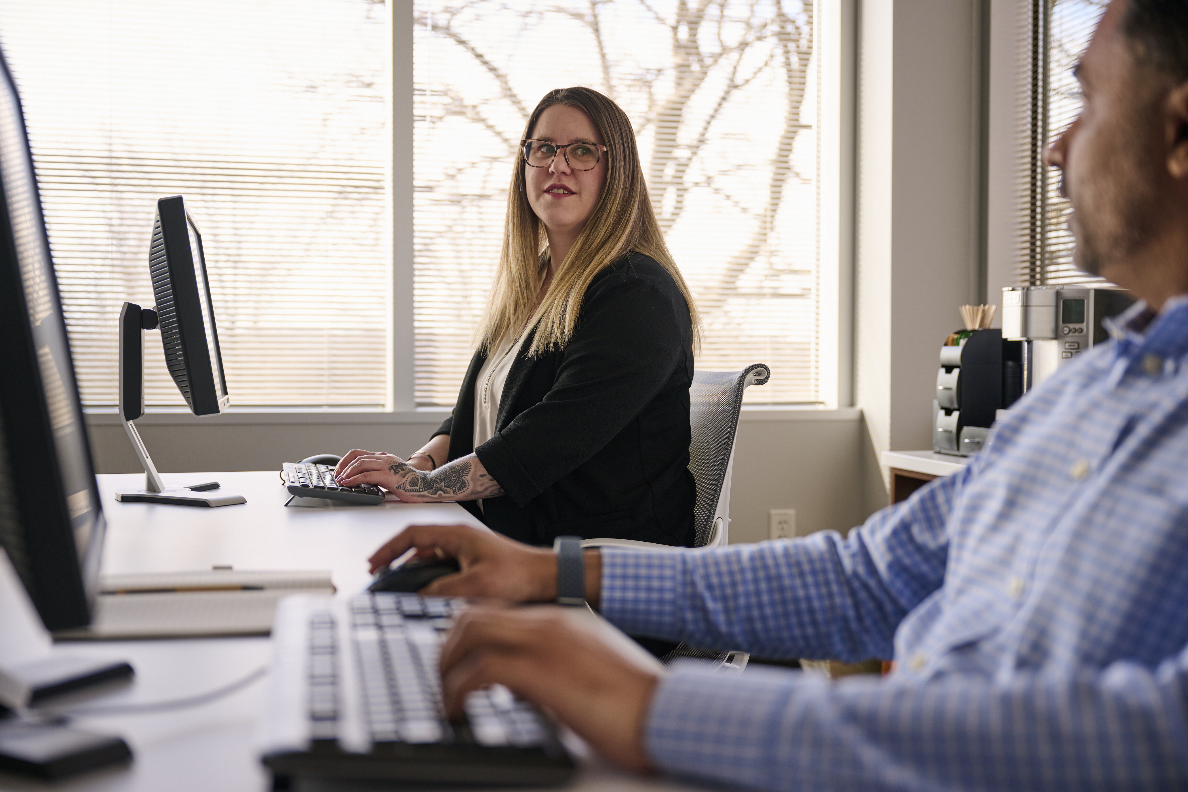 Healthcare IT professionals working at computers and discussing digital ultrasound IT solutions.