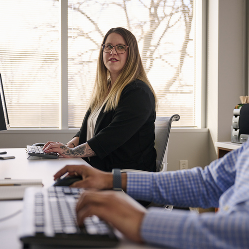 Healthcare IT professionals working at computers and discussing digital ultrasound IT solutions.