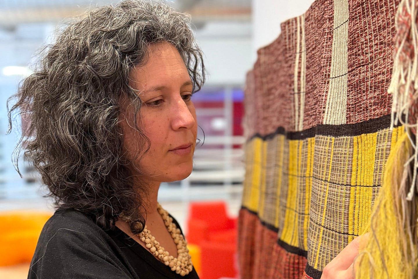 Rachel Dana installs her warp-faced weaving in preparation for an exhibition display.