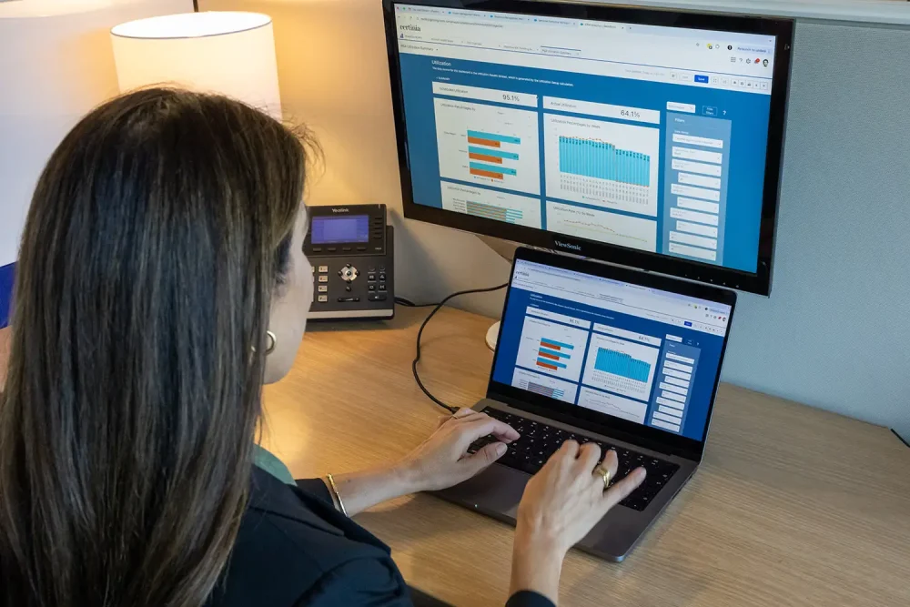 Employee on laptop using Certinia's Schedule Optimization with AI to spot bottlenecks and ensure on-time project delivery