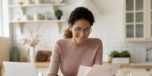 Happy millennial hispanic lady review printed paper documents financial reports