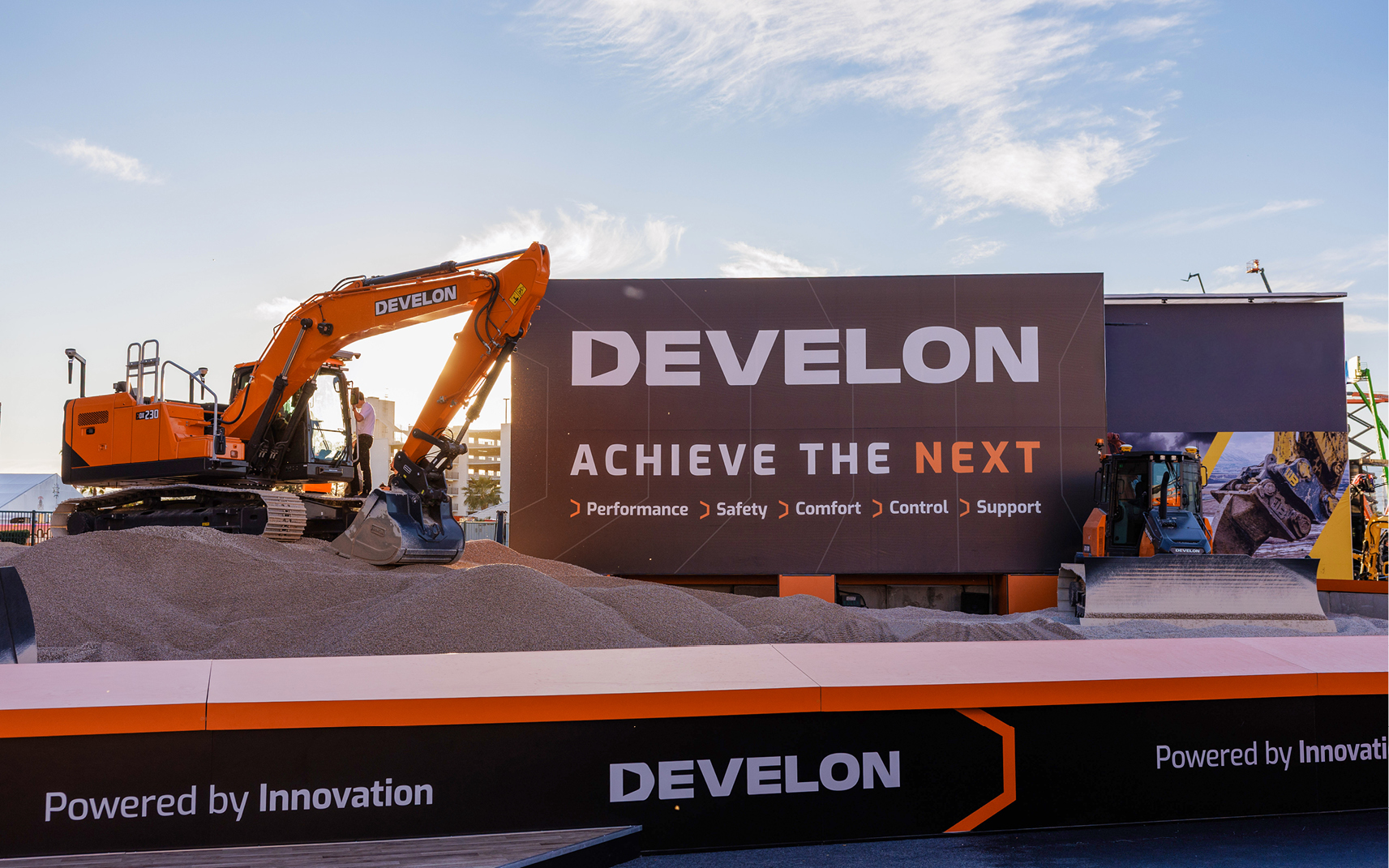 A DEVELON compact track loader and mini excavator working on a job site.