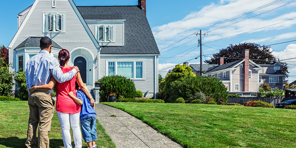 family holding each other in front of a house