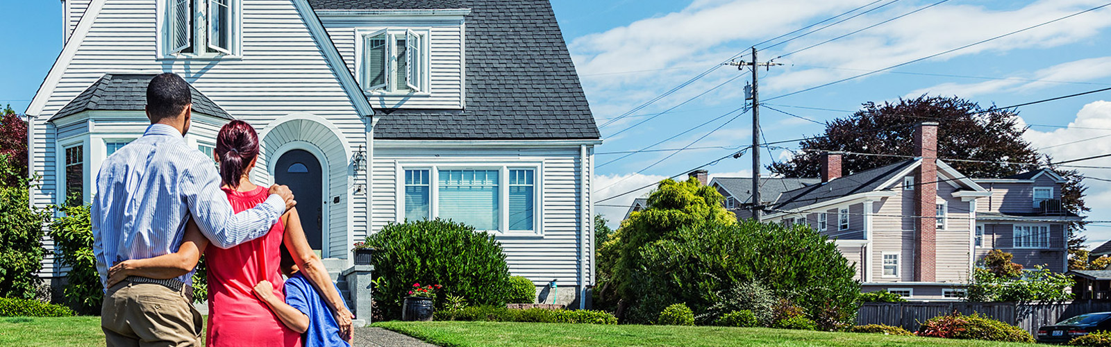 family holding each other in front of a house