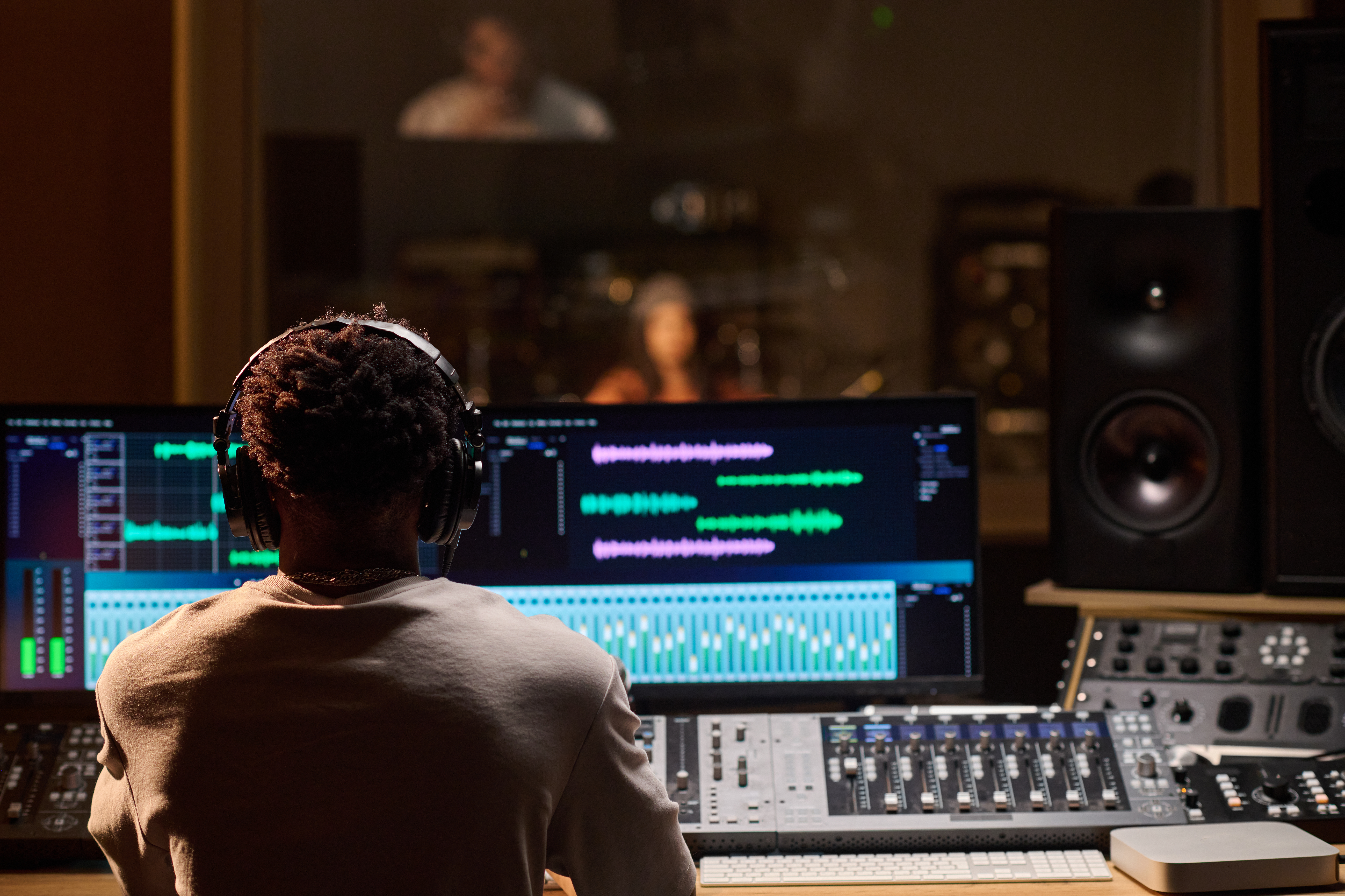 An AV technician uses live event production software AV event production tools while controlling the feeds from multiple microphones. 