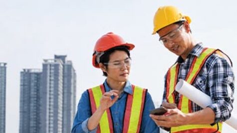 ICT infrastructure engineers collaborating on a building project using mobile tech