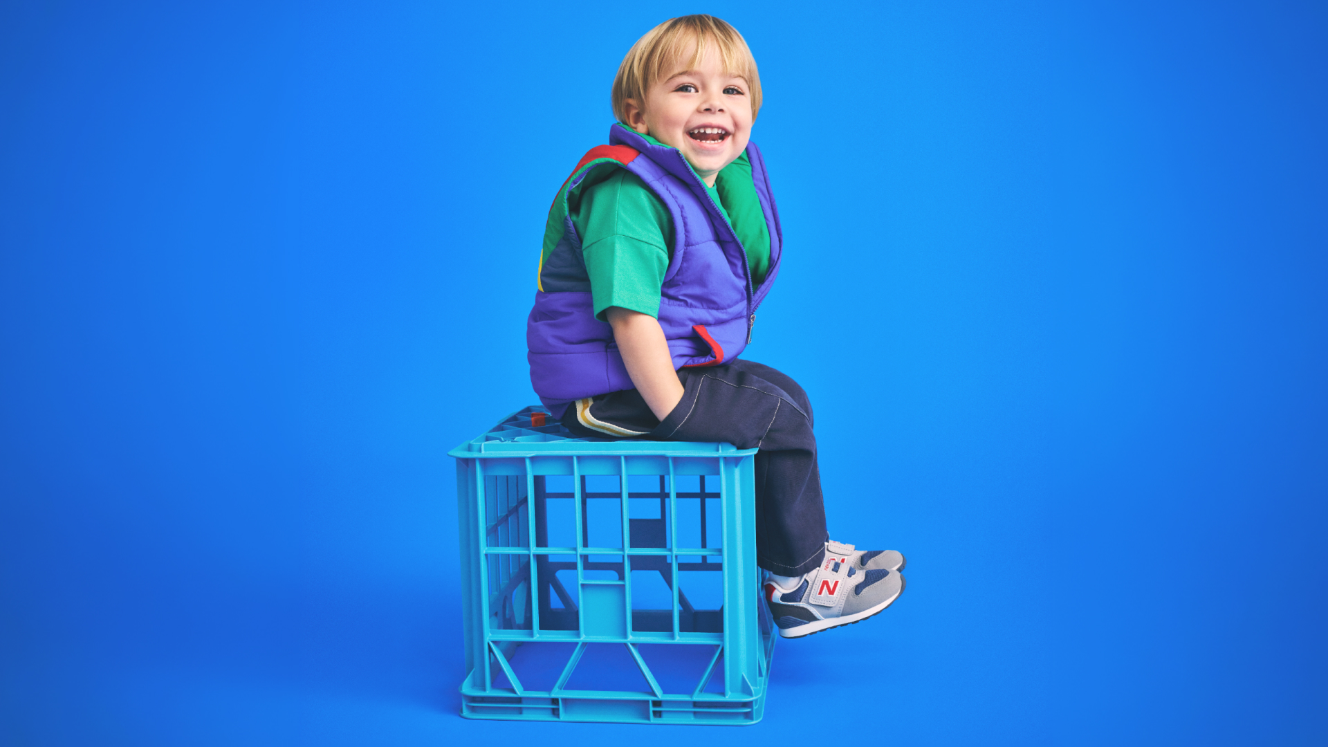 Boy sitting on crate wearing sneakers