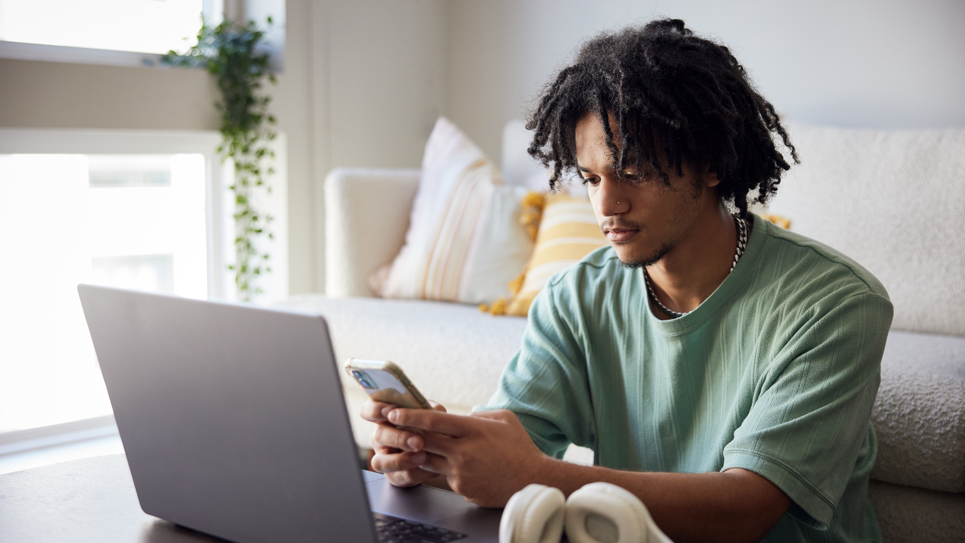 College student with laptop and mobile phone in dorm room