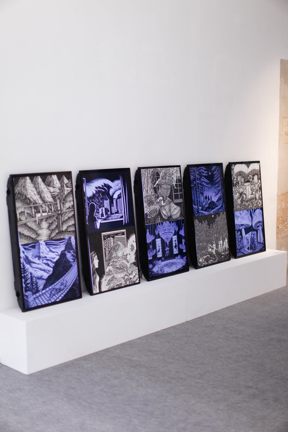 Framed black and blue graphic artworks displayed in a gallery