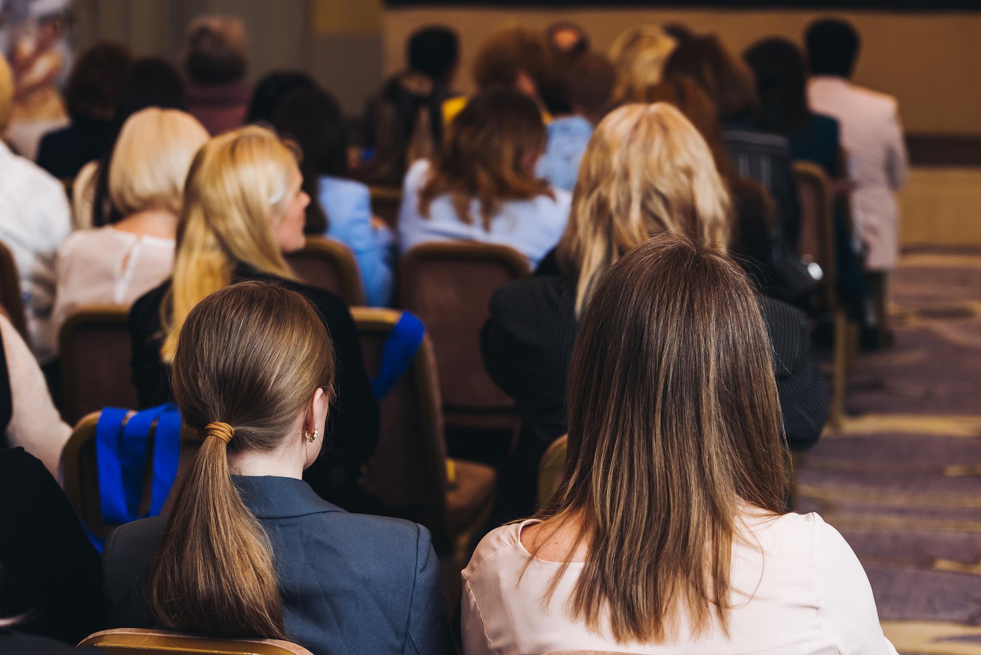 Audience at a symposium meeting in a conference room.