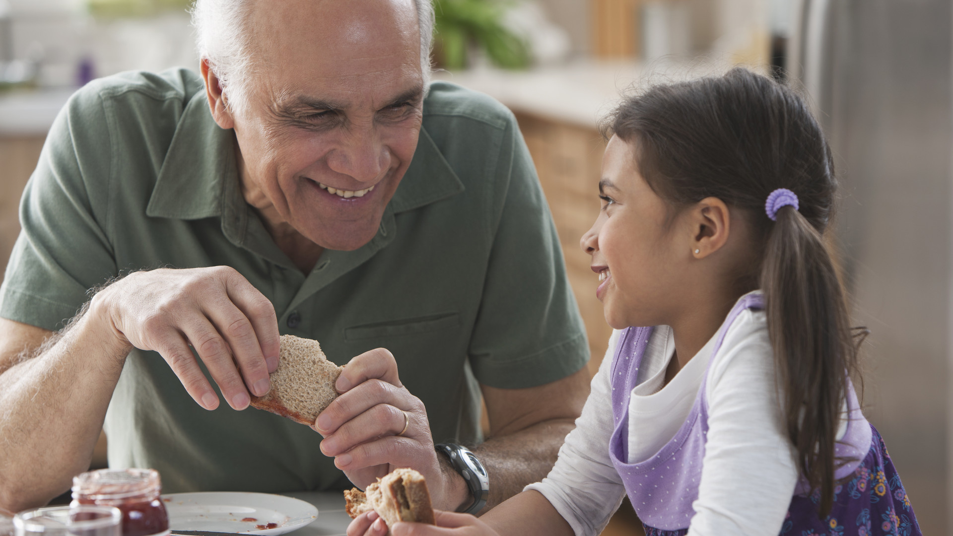 Grandfather and granddaughter eating sandwiches