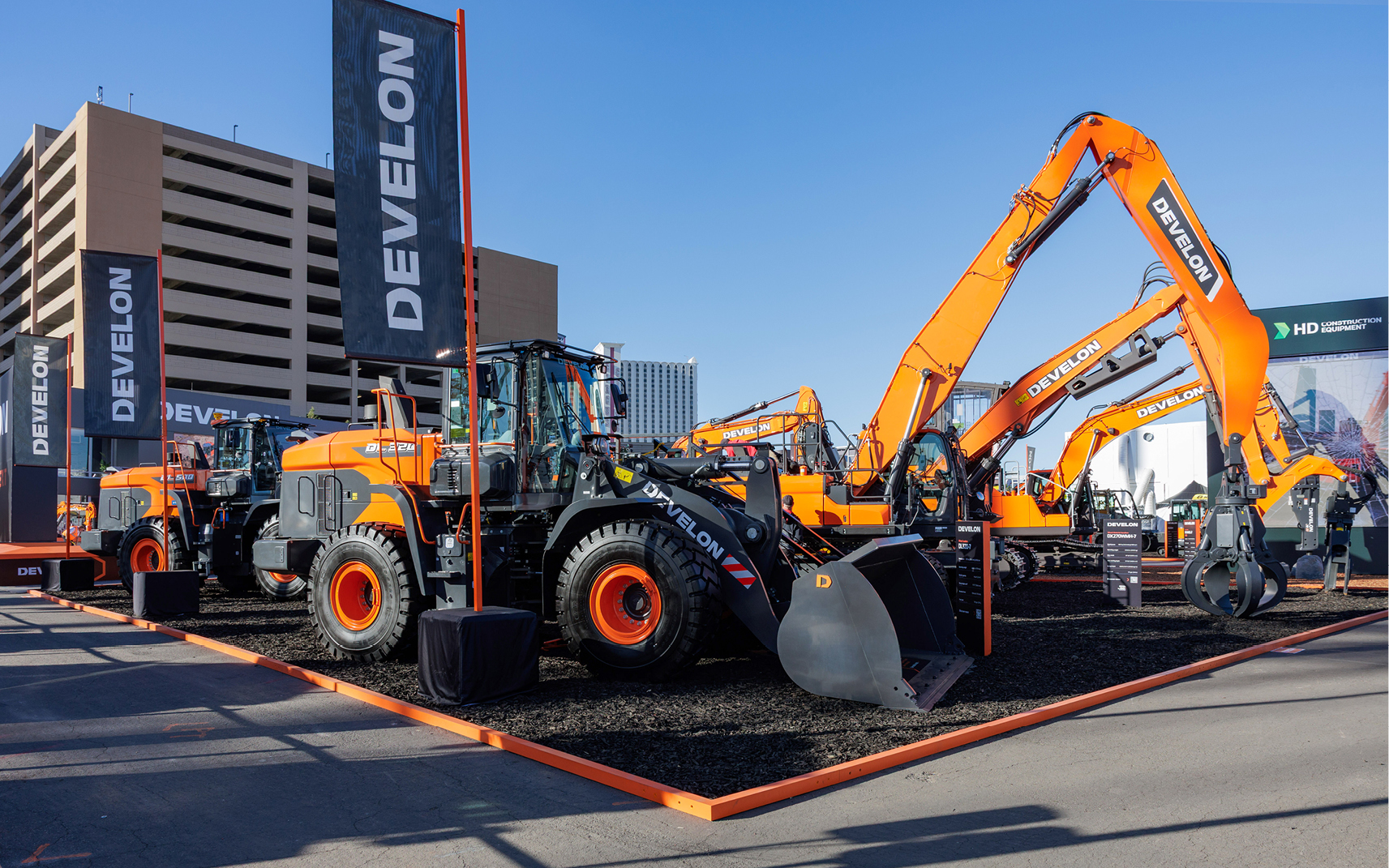 Orange DEVELON wheel loaders and excavators displayed in the DEVELON CONEXPO 2026 outdoor booth.