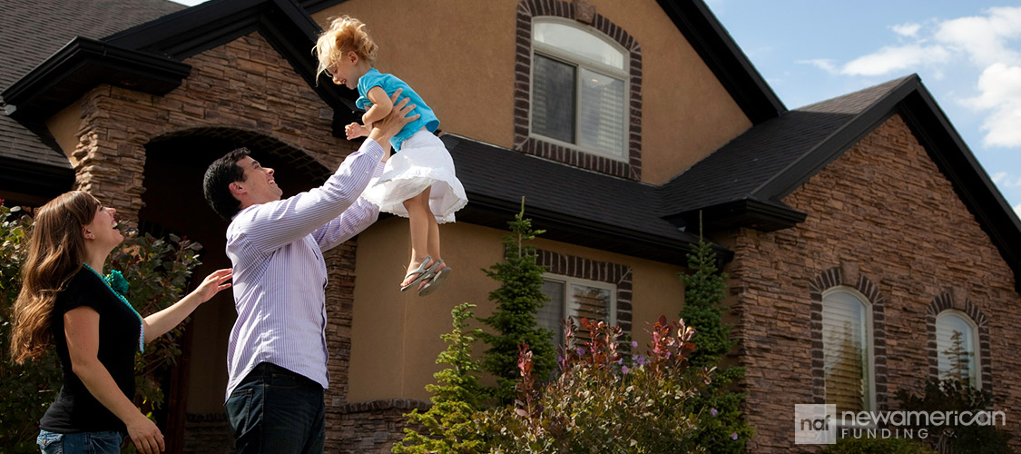 Happy family playing outside of their new home