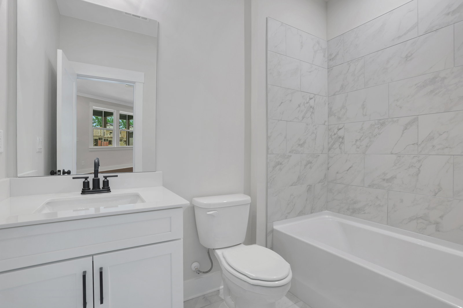secondary bathroom with white cabinets and tile flooring