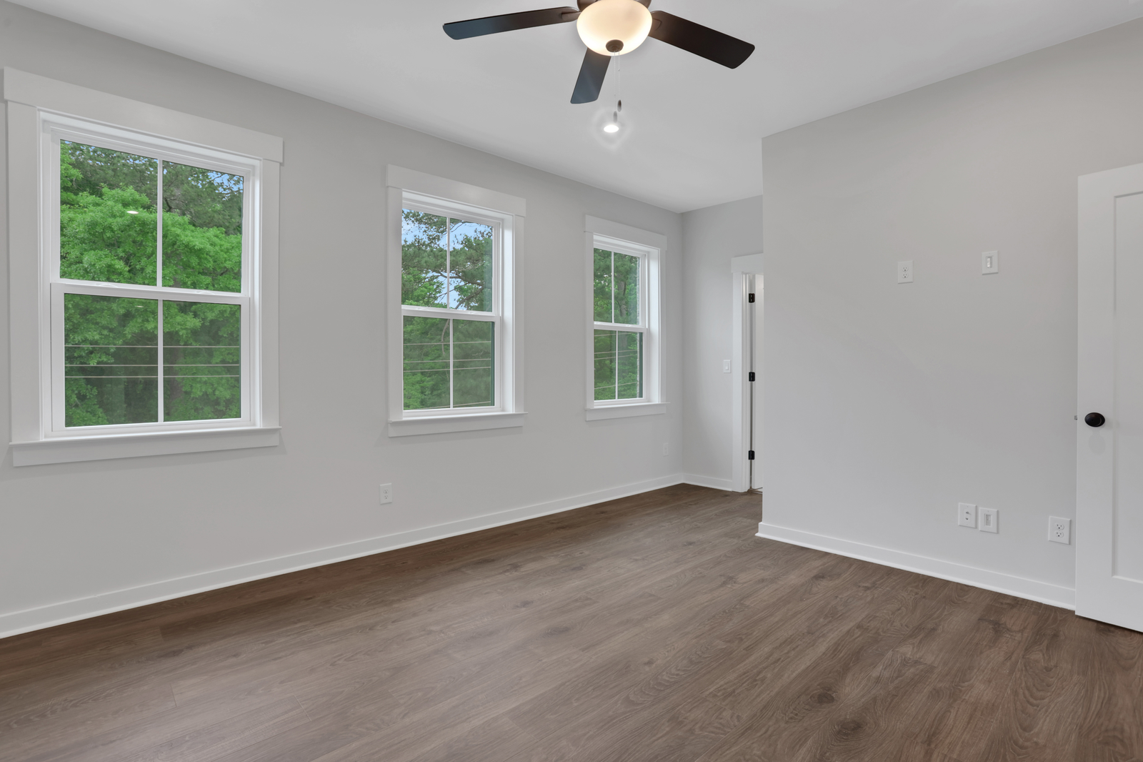 primary bedroom with windows and hard surface floors