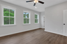 primary bedroom with windows and hard surface floors