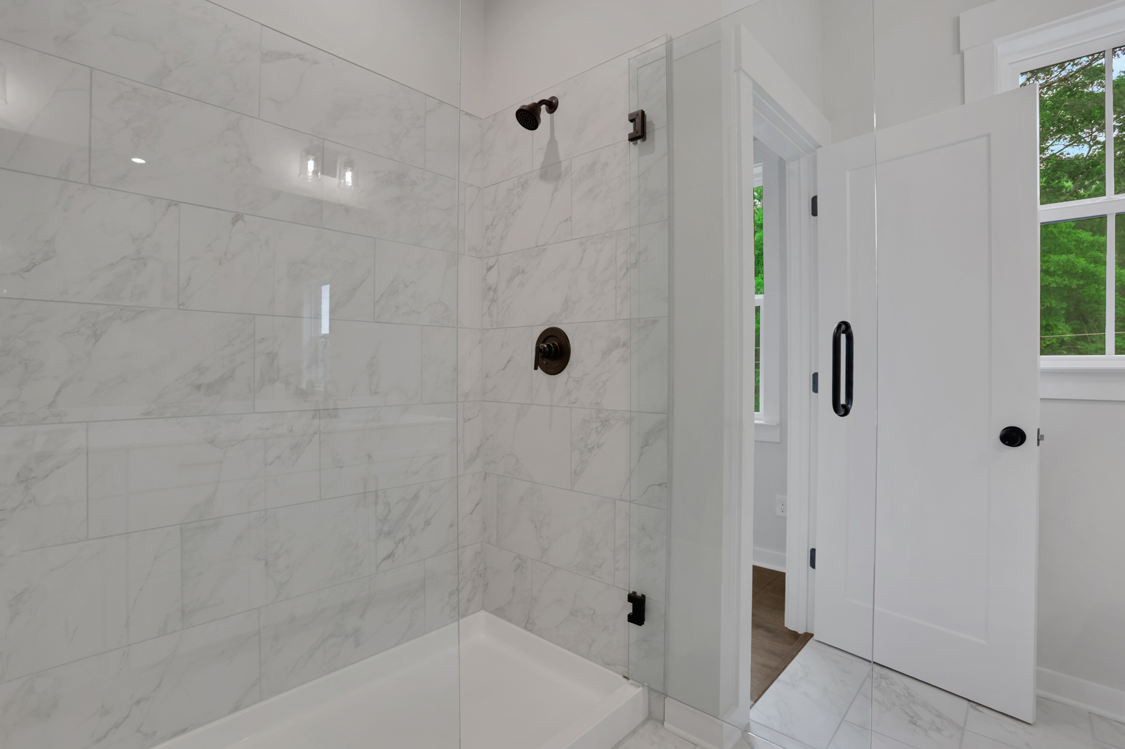 primary bathroom with walk-in shower and tile flooring