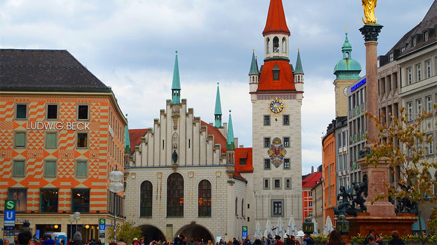 The historic Old Town Hall and its clock tower rise above a bustling city square in Munich, Germany.