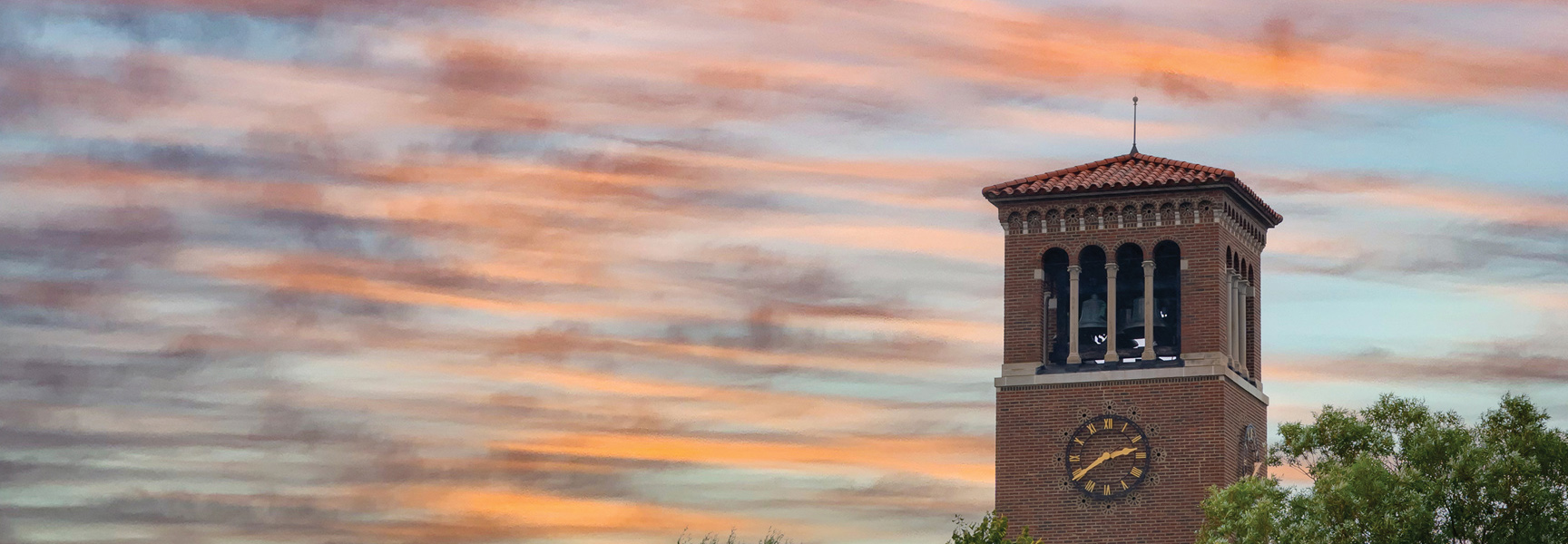 The Miller Bell Tower at the Chautauqua Institution in New York stands against a colorful sunset sky.
