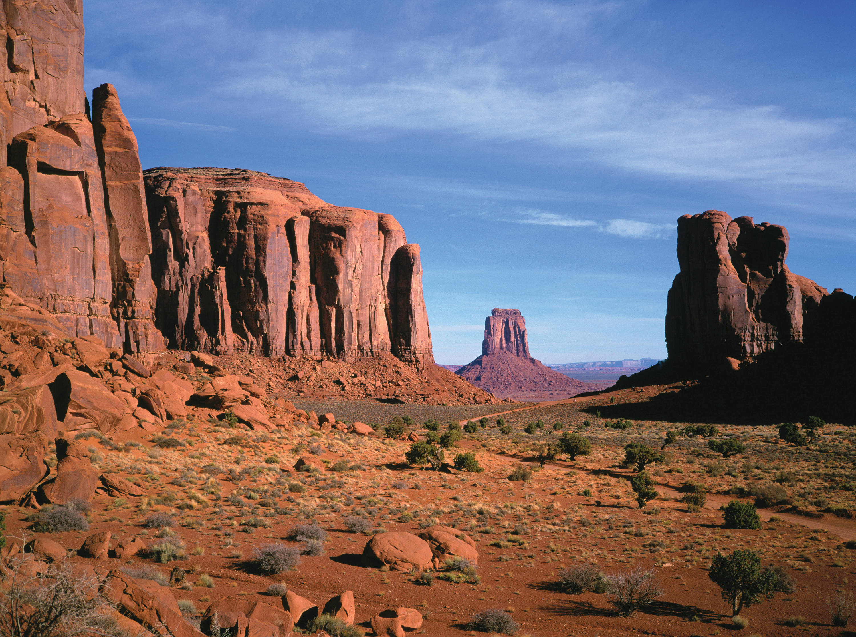 Massive red sandstone mesas and buttes rise from the desert floor in Monument Valley on Navajo lands in Arizona.