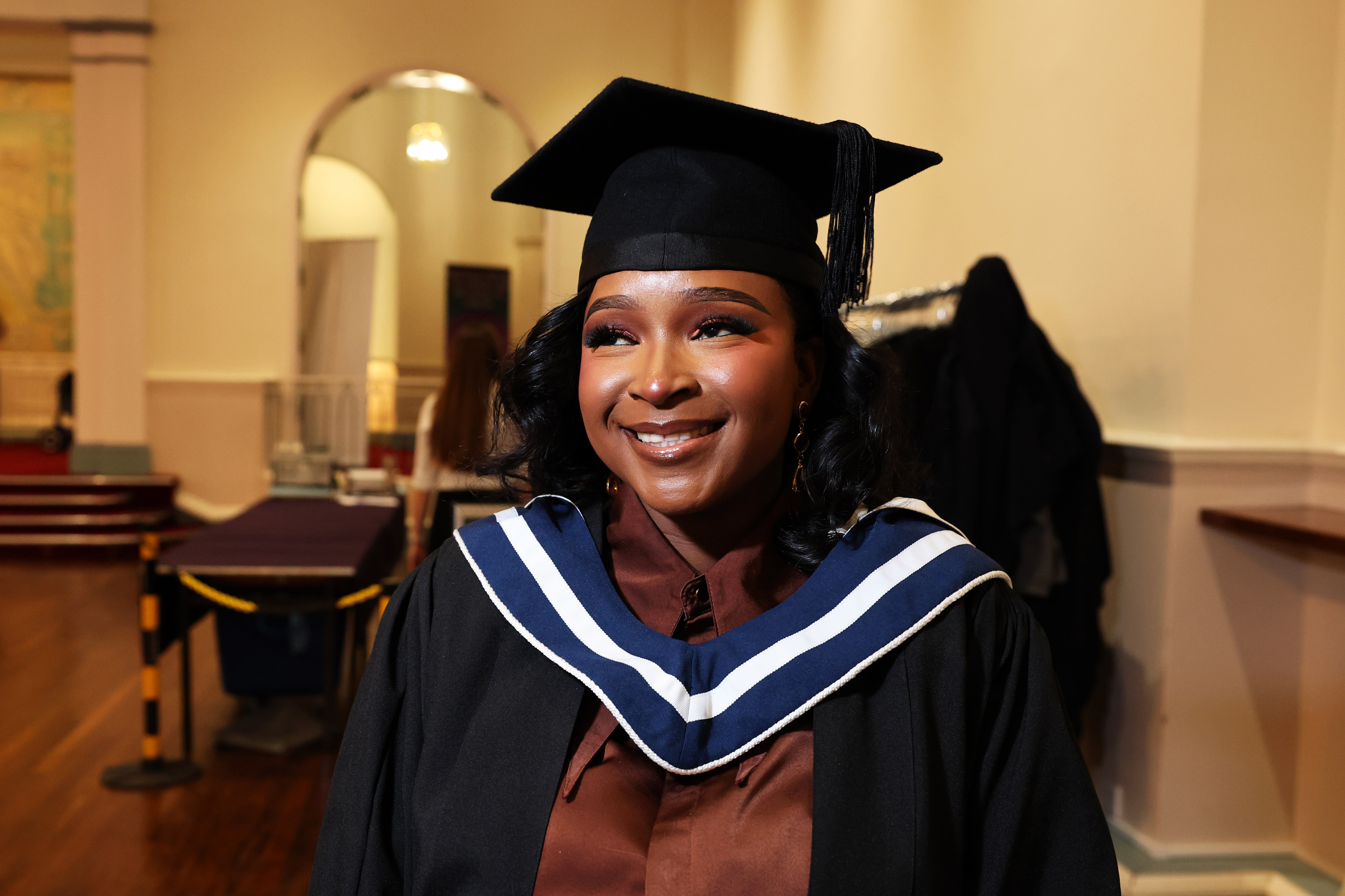 Close up of female graduate in cap and gown looking proud and smiling