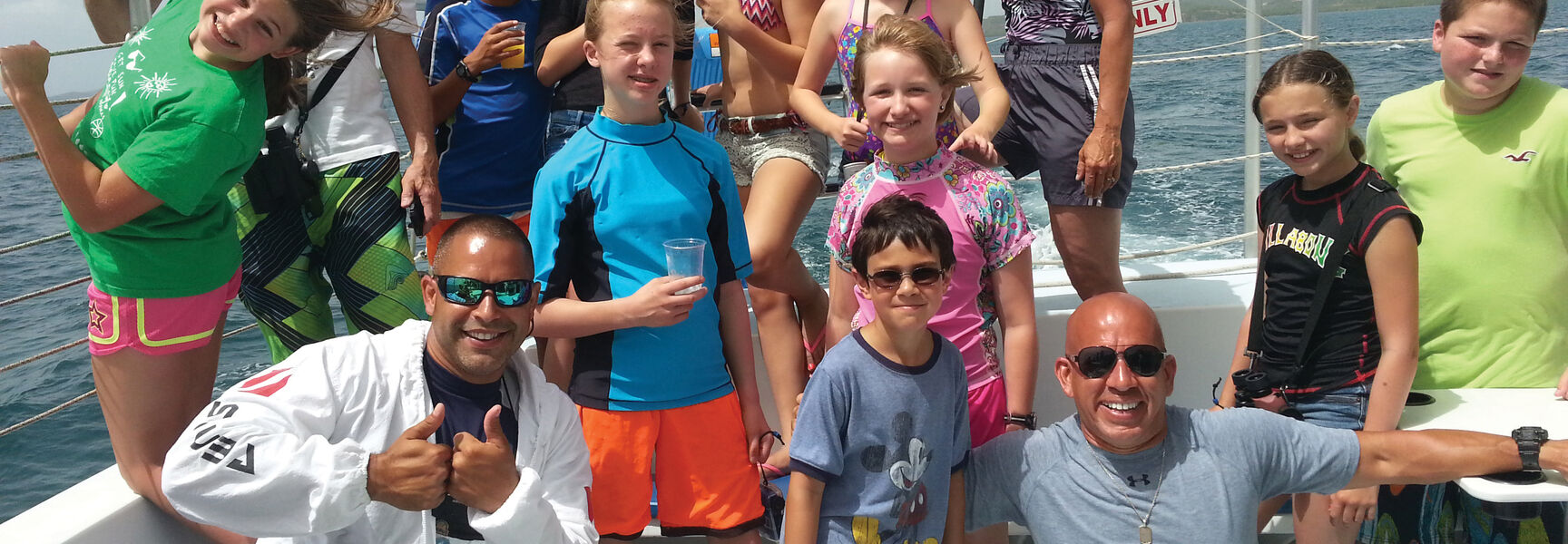 A smiling group of grandparents and children pose on a boat during a snorkeling and wildlife excursion in Puerto Rico.