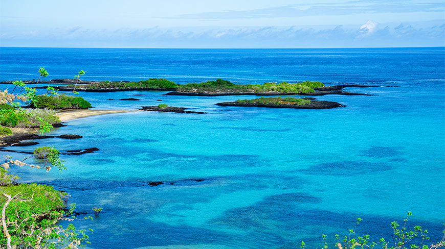 A view of turquoise water and rocky islands at Baroness Point on Floreana Island in the Galapagos.