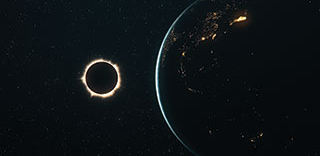 A total solar eclipse is visible from space, with the sun's corona glowing brightly next to the partially illuminated Earth.