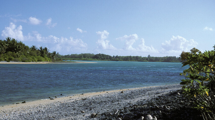 A rocky beach and blue lagoon on the remote island of Nikumaroro, where Dr. Richard Pettigrew searched for Amelia Earhart’s missing aircraft.