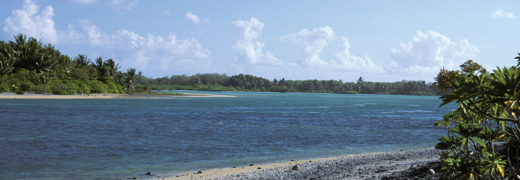 A rocky beach and blue lagoon on the remote island of Nikumaroro, where Dr. Richard Pettigrew searched for Amelia Earhart’s missing aircraft.