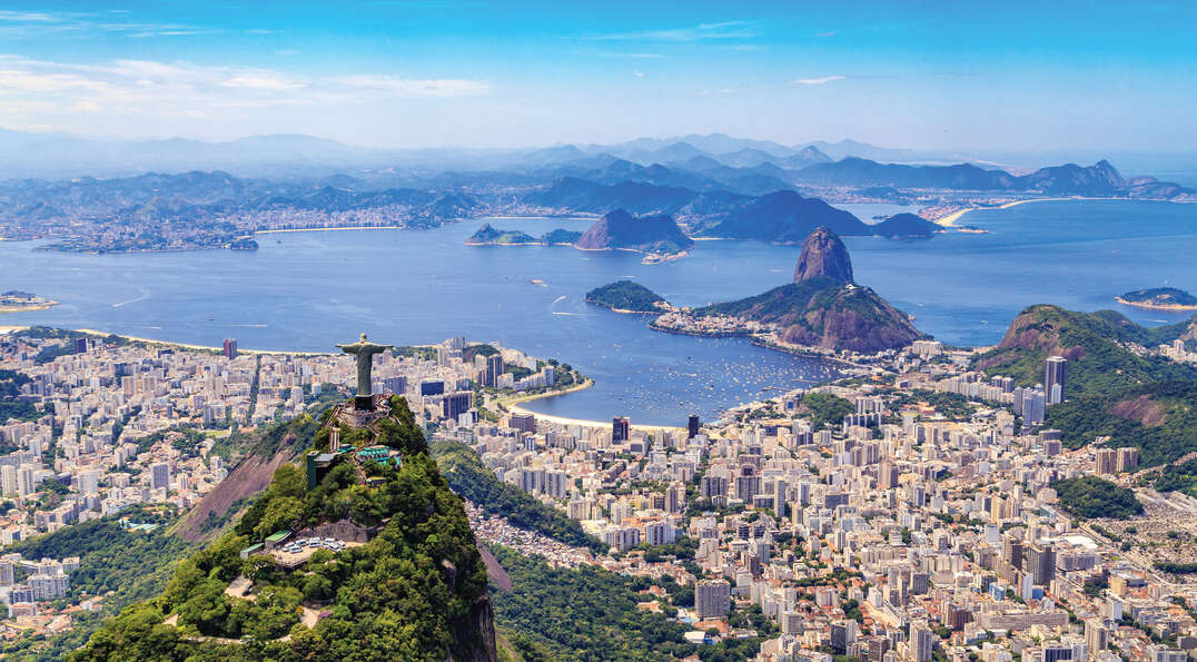 Aerial view of Christ the Redeemer overlooking the cityscape and coastline of Rio de Janeiro, Brazil.