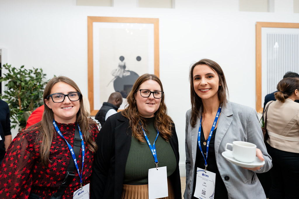 Three women standing together posing for camera