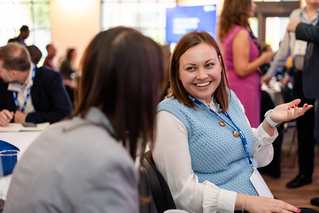 Two women at conference, smiling and talking