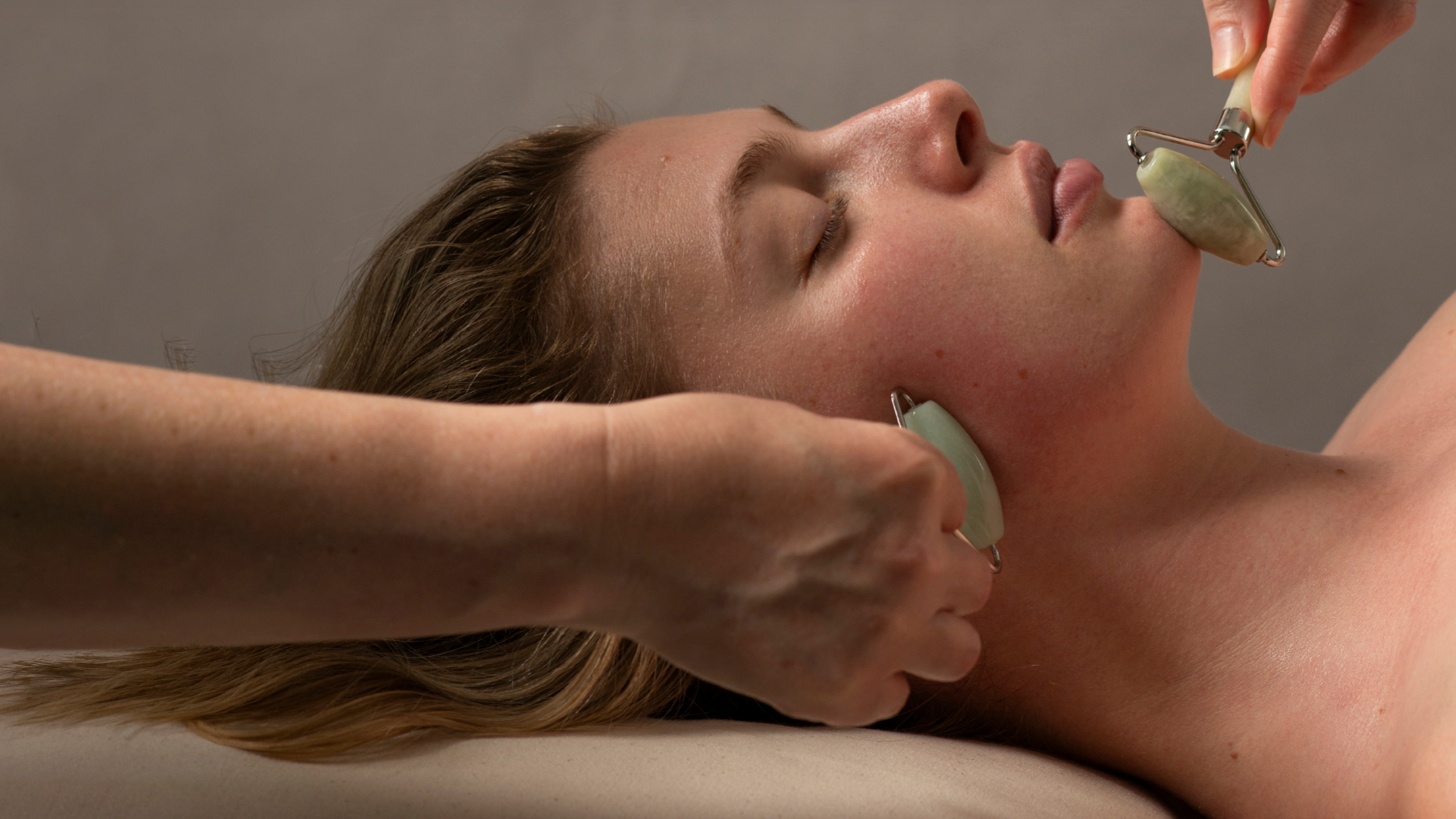20% off Spring Glow Spa Package, woman in spa environment with jade rollers on her face