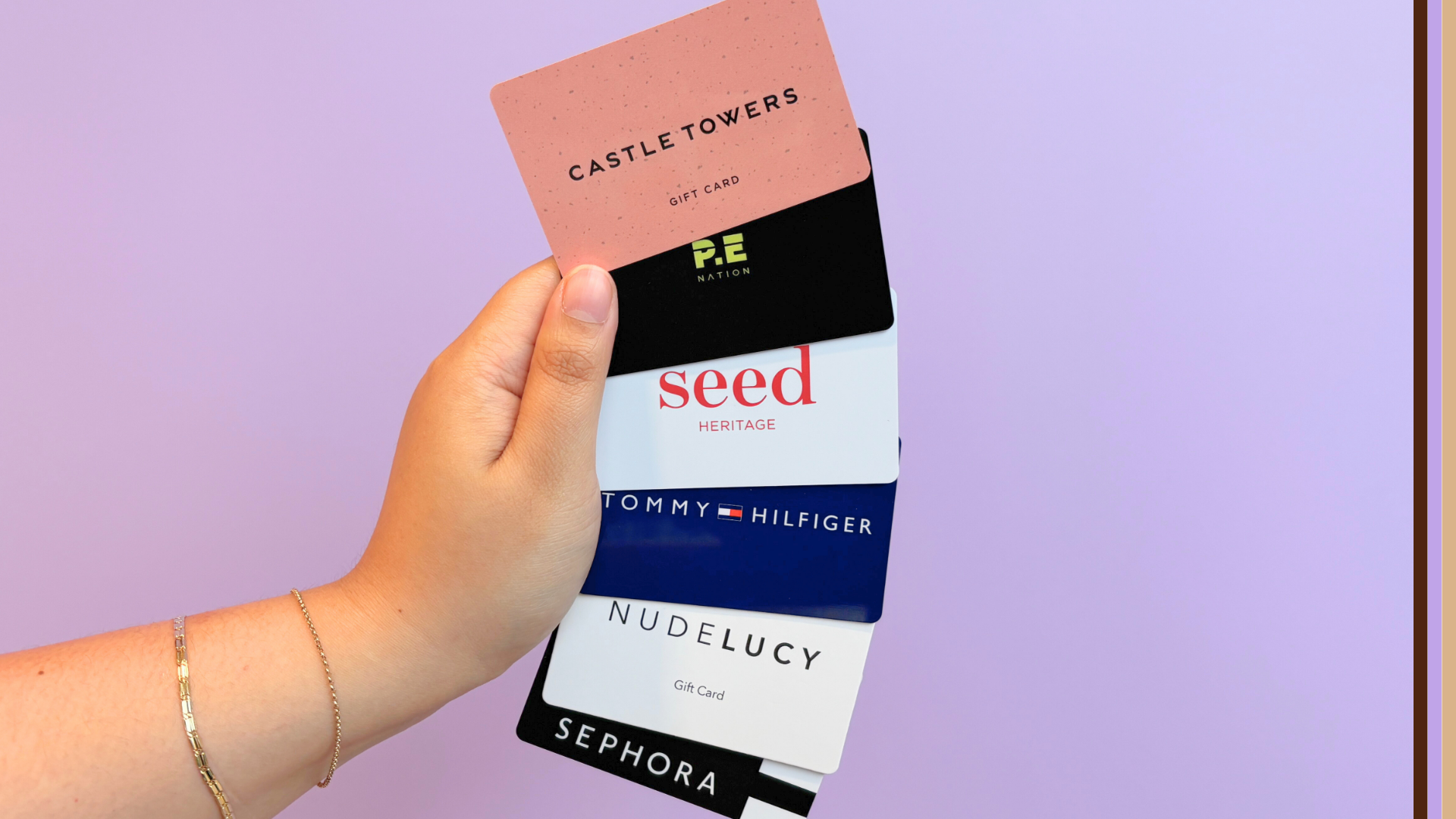 hand holding Castle Towers, P.E Nation, Seed Heritage, Tommy Hilfiger, Nude Lucy and Sephora gift cards