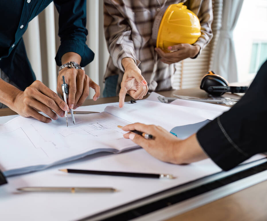 Architects collaborating over blueprint