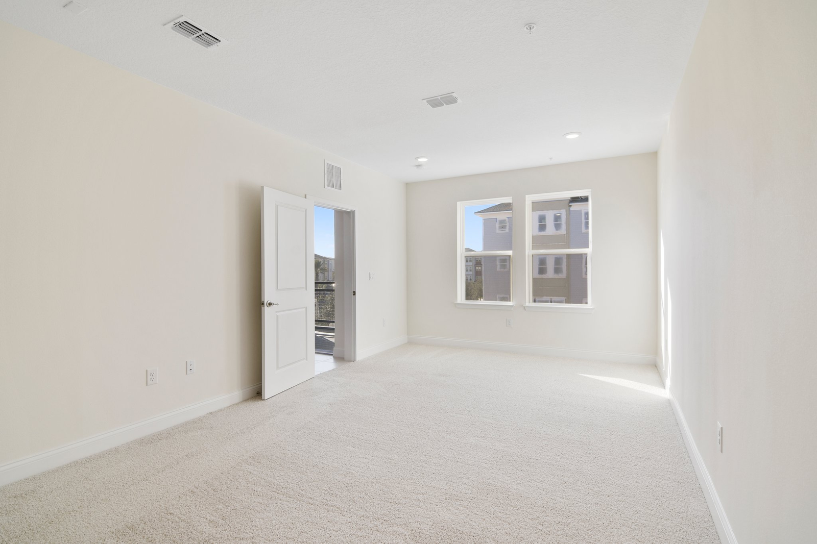 primary bedroom with carpet and two windows